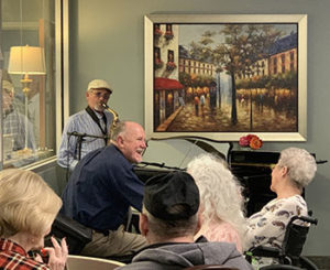 residents listening to entertainer playing the paino